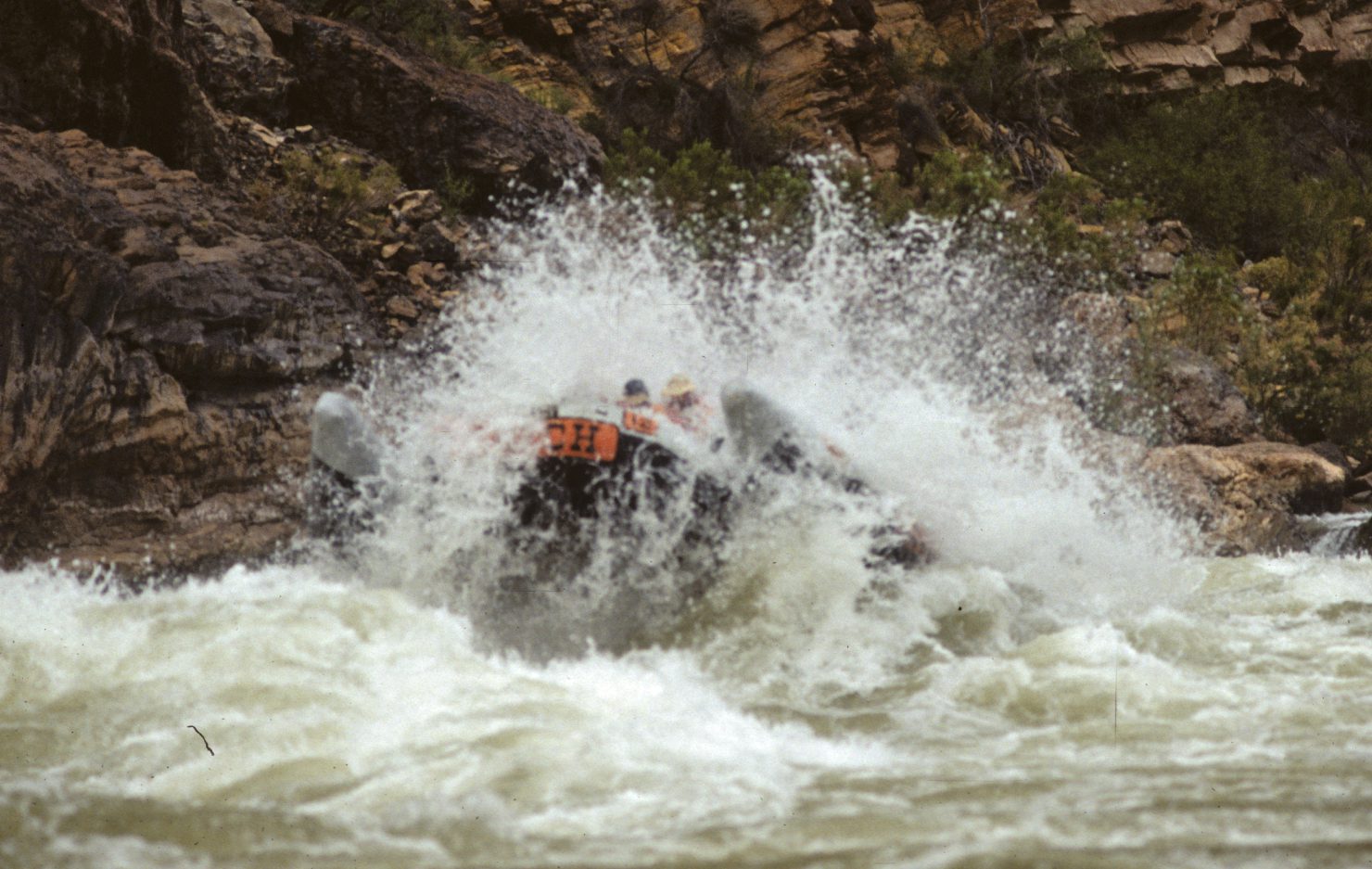 A person is riding on the back of a boat in rough water.