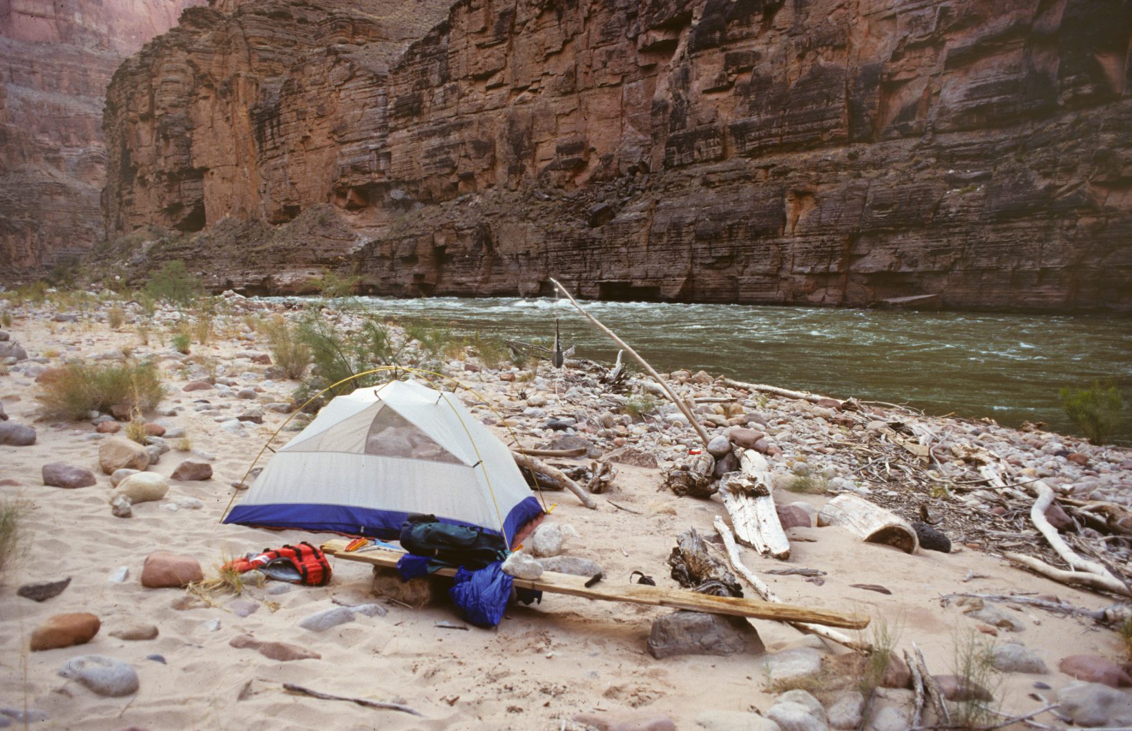 A tent and poles on the beach near water