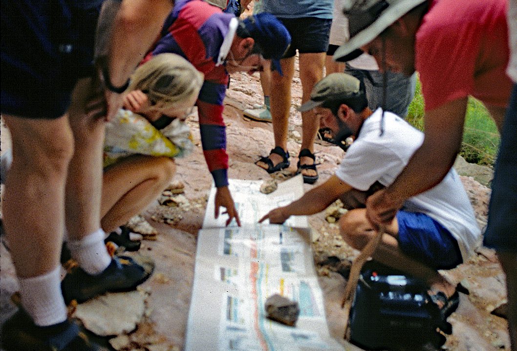 A group of people looking at rocks on the ground.