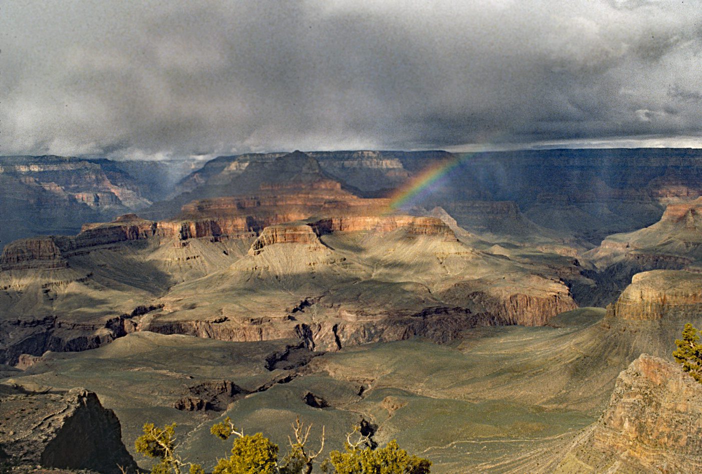 A rainbow is seen in the distance as it comes out of the clouds.